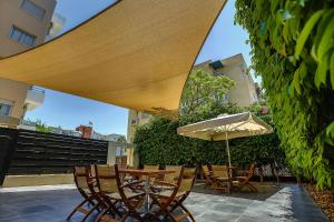 Una mesa y sillas con una sombrilla en un patio. en Vega Apartments, en Limassol