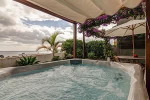 a hot tub on a patio with a view of the ocean at epicenter SANTACRUZ in Lagoa