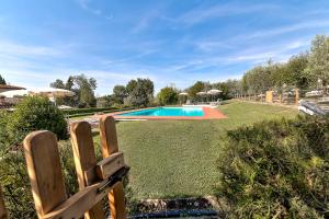 a yard with a swimming pool and a fence at Podere Le Rondini in Montespertoli