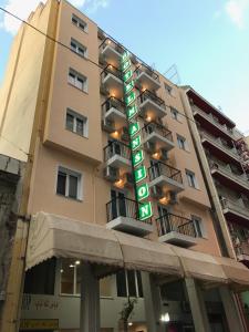 un edificio con una señal de hotel delante de él en Mansion Hotel en Atenas