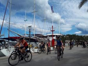a group of people riding bikes near a boat at Holiday home Gariful in Milna