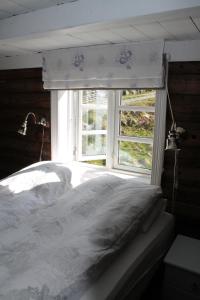 Schlafzimmer mit einem weißen Bett und einem Fenster in der Unterkunft Molandstveit in Osestad