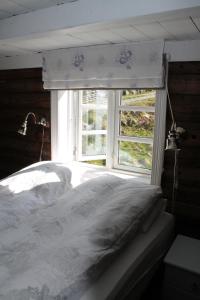 a bedroom with a white bed with a window at Molandstveit in Osestad