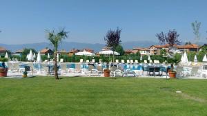una piscina con sillas, mesas y sombrillas en Elegance Spa Hotel en Ognyanovo