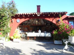 an archway in a patio with a table and flowers at Casa con jardín frente Playa de Burriana in Burriana