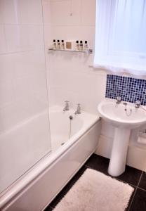 a bathroom with a tub and a sink and a toilet at Newly Refurbished in Town Center in St Andrews