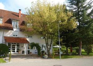 ein weißes Haus mit Bäumen davor in der Unterkunft Hotel Schloßmatt in Schwörstadt