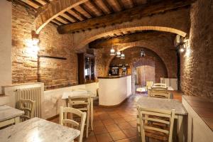 a restaurant with tables and chairs in a building at Hotel Porta Romana - LuceHotels in Siena