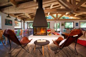 Una sala de estar con sillas y chimenea. en Ostello Alpino, en Bormio