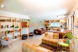 a living room with a couch and a tv at Ostello Alpino in Bormio