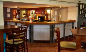 a bar in a restaurant with tables and chairs at New Inn by Greene King Inns in Newport
