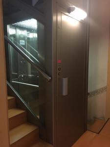un ascensor con una puerta de cristal y escaleras en Ciudad Condal Hostal - Paseo de Gracia, en Barcelona 51 fotos más