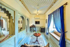 un soggiorno con soffitto a cassettoni e tavolo di Udai Kothi a Udaipur