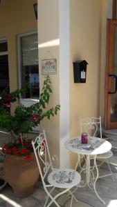 a table and two chairs sitting next to a building at Eros Beach Hotel in Benitses