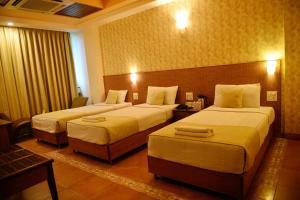Postel nebo postele na pokoji v ubytování Goa Woodlands Hotel