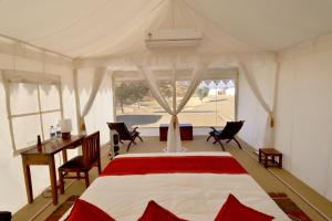 um quarto com uma cama e uma secretária numa tenda em Dhora Desert Resort, Signature collection by Eight Continents em Shaitrāwa