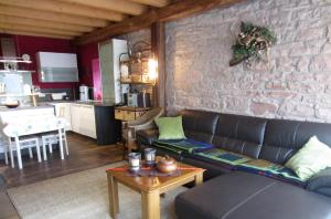a living room with a couch and a brick wall at Wohnung auf einem alten Bauernhof in Neuheilenbach