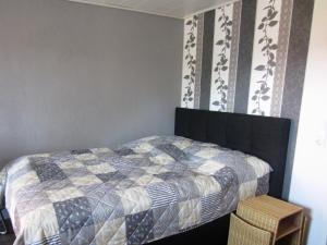 a bedroom with a bed with a quilt on it at Wohnung auf einem alten Bauernhof in Neuheilenbach