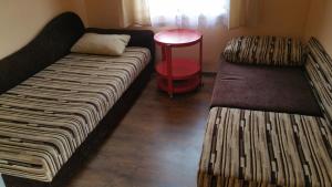アウグストゥフにあるBabci domekのベッド2台と赤いテーブルが備わる客室です。