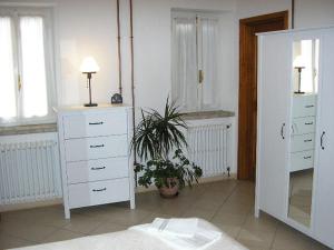 sypialnia z białymi komodami i doniczką w obiekcie B&B IL BOSCHETTO w mieście Calestano