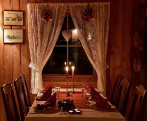 a dining room table with candles and a window at Toftenes Sjøhuscamping in Alsvåg