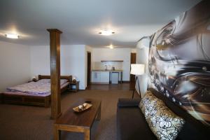 a hotel room with a bed and a living room at Penzión Anima in Kaluža
