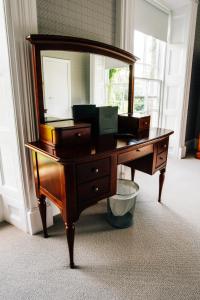 a wooden desk with a mirror on top of it at Belmont House Hotel in Banbridge