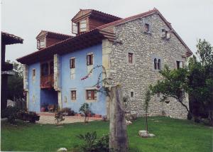 a large stone house with a tree in front of it at El Ama De Llaves in Hontoria