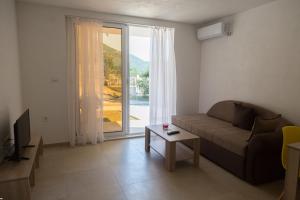 a living room with a couch and a large window at Del Mar Apartments in Čanj