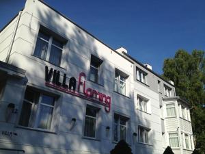 a white building with a red sign on it at Villa Flaming in Sopot