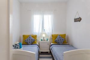 two beds in a small room with yellow and blue pillows at Nono Frano in Prožura