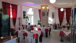 um restaurante com mesas brancas e cortinas vermelhas em Casa Eraldo em Castellaccia