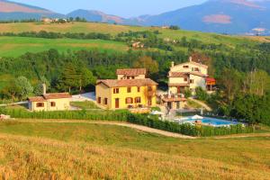 una casa grande en una colina con piscina en Agriturismo Borgo Umbro, en Costacciaro