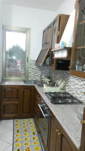una cucina con lavandino e piano cottura forno superiore di Casa Gialla a Santo Stefano di Magra