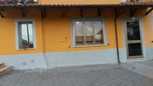 un edificio arancione con due finestre e una porta di Casa Gialla a Santo Stefano di Magra