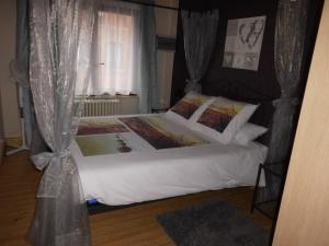 een slaapkamer met een bed met witte lakens en een raam bij 't Eenvoud - Logies in Knokke-Heist