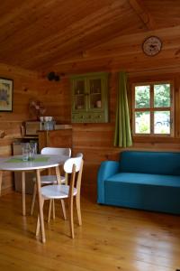 salon z niebieską kanapą i stołem w obiekcie Le Jardin des Pierres Brunes w mieście Saint-Jean-des-Ollières