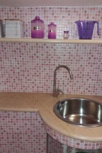 a kitchen counter with a sink and shelves at Barco Apartment in Ostuni +19 photos