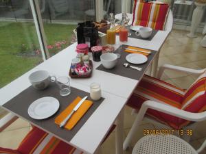 a table with plates and utensils on it at chambres d'hotes et meublés les Hortensias in Lillers