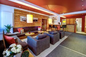 a large living room with couches and a kitchen at AlpenParks Hotel Maria Alm in Maria Alm am Steinernen Meer