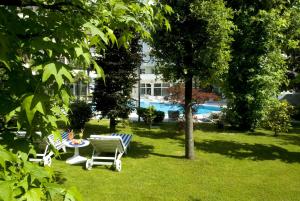 a garden with a table and chairs in the grass at Hotel La Residence & Idrokinesis in Abano Terme