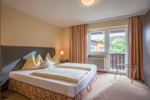 a bedroom with a bed and a large window at Sporthotel Austria in Sankt Johann in Tirol +84 photos