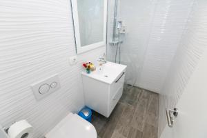 een witte badkamer met een toilet en een wastafel bij Rose Apartment in Split