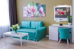 a living room with a blue couch and a table at Hotel Sluch in Starokostyantyniv