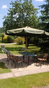 une table et des chaises avec un grand parasol dans l'établissement Pokoje Rożnów, à Rożnów