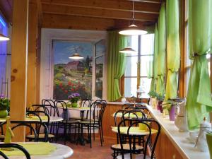 a restaurant with green curtains and tables and chairs at Pension Spreeeck in Habrachćicy