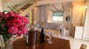 un tavolo con una bottiglia di vino e fiori di Villa Ellie ad Agios Stefanos
