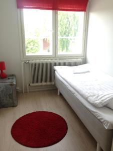 1 dormitorio con 1 cama con alfombra roja y ventana en DAG-15 en Korpo