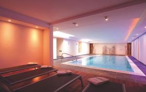 a large swimming pool in the middle of a room at Hotel Garni Muttler Alpinresort & Spa in Samnaun