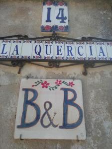 un cartello sul lato di un edificio che dice: di B&B La Quercia a San Gregorio
